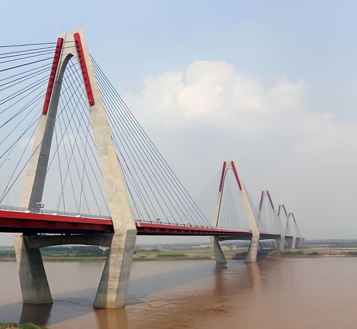 Ponte estaiada com pilares de concreto sobre um rio largo.